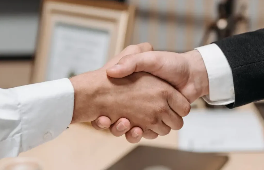Zwei Geschäftspartner reichen sich die Hand um das Geschäft zu besiegeln